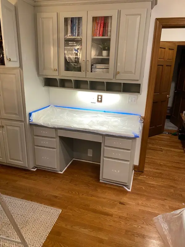 Gray built-in desk with blue tape and plastic on the counter, Brentwood, TN