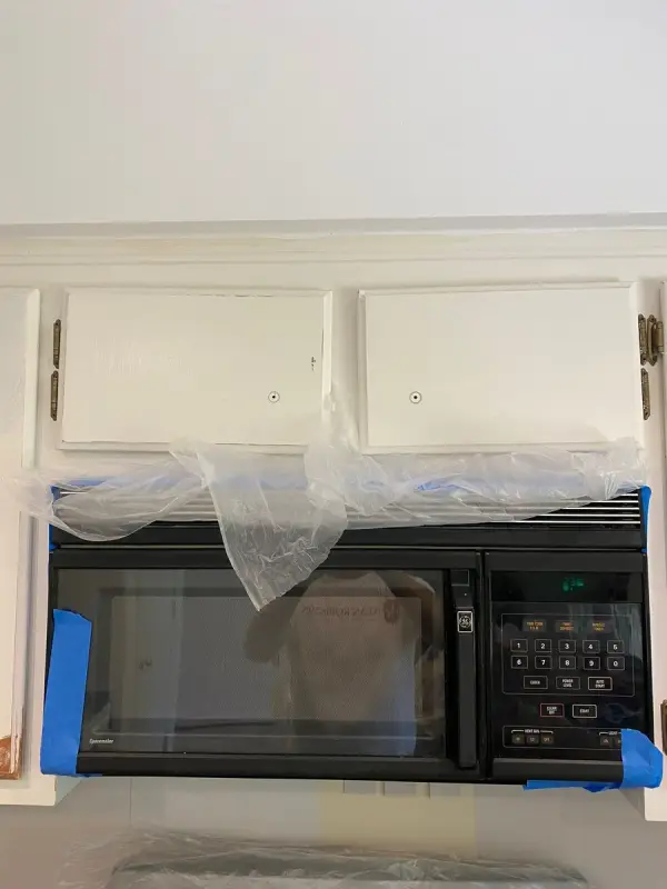 White upper doors above a microwave masked in plastic, Bellevue, TN