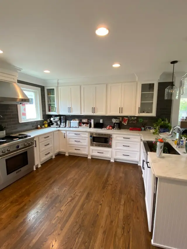 Finished white kitchen cabinets under a dark gray tile backsplash, Brentwood, TN