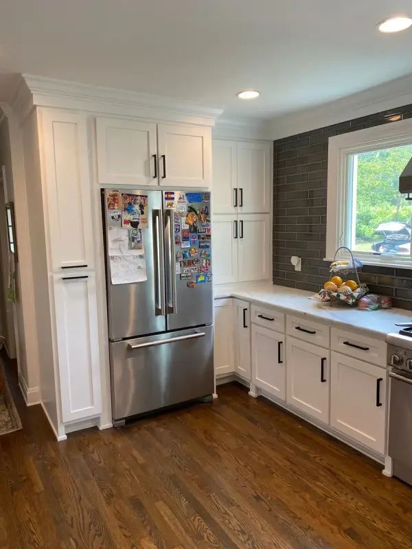 Tall white pantry cabinets beside a stainless refrigerator, Brentwood, TN