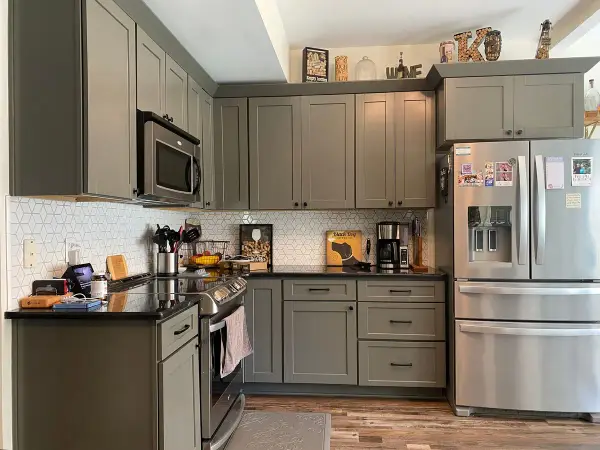 Gray-green shaker kitchen cabinets with black counters and white tile, Franklin, TN