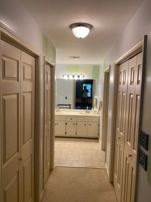 Hall view to a bathroom vanity with cream doors, Bellevue, TN