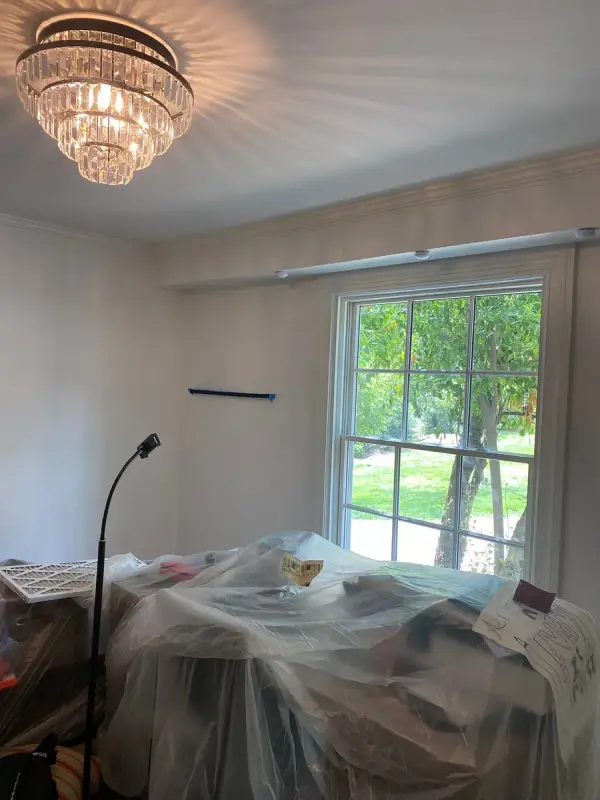 Bedroom with gray walls and furniture under plastic, Brentwood, TN