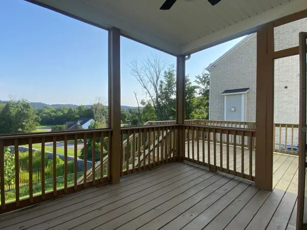 Screened porch with brown-stained rails and hillside view, Bellevue, TN