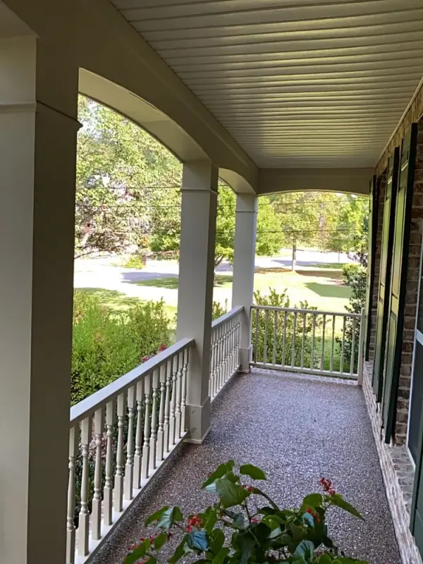 White porch columns, railing and beadboard ceiling along a brick wall, Bellevue, TN