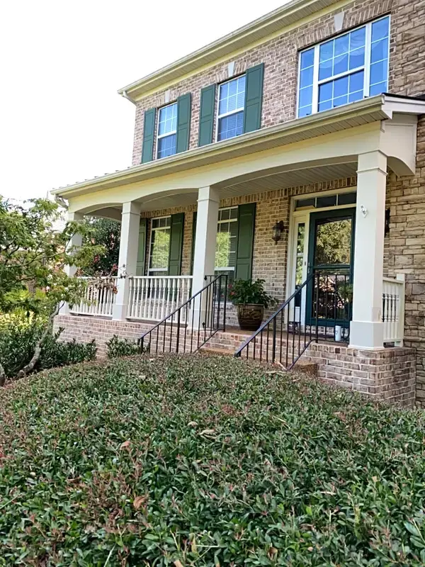 Brick two-story front with green shutters and white porch columns, Bellevue, TN