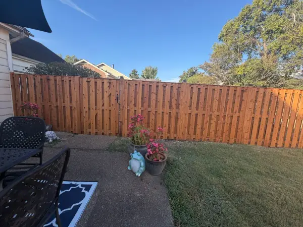 Stained board-on-board fence behind a patio with flowers, Bellevue, TN