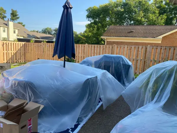 Patio furniture wrapped in plastic before fence staining, Bellevue, TN