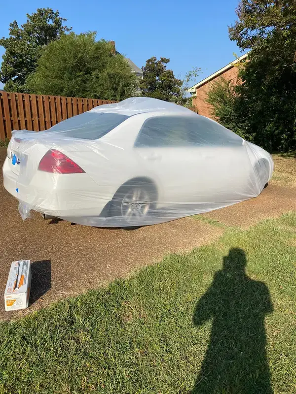 Parked car covered in plastic beside the fence line, Bellevue, TN