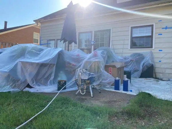 House wall taped and furniture wrapped beside a sprayer, Bellevue, TN