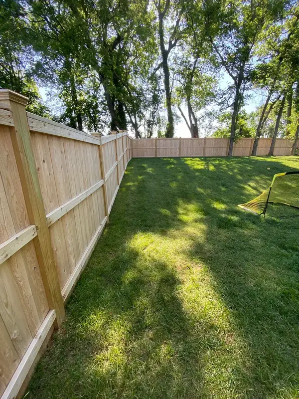 Long run of raw privacy fence along a tree line, Thompson Station, TN