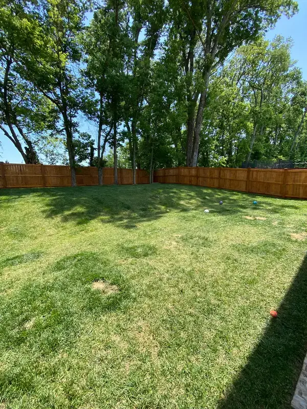 Stained privacy fence across the back of a new lawn, Thompson Station, TN
