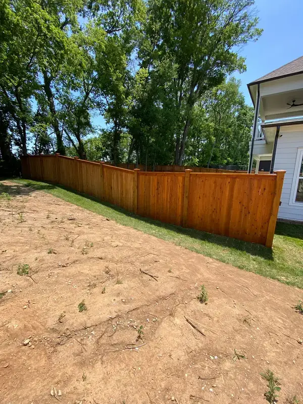 Cedar-tone stained fence along a bare backyard bed, Thompson Station, TN