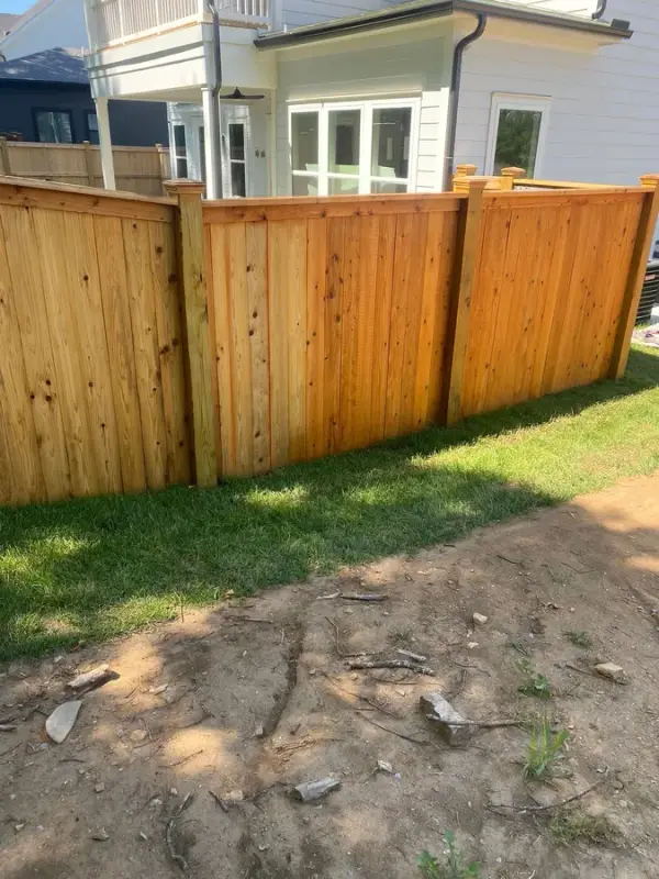 Privacy fence run half stained, cedar tone beside raw boards, Thompson Station, TN