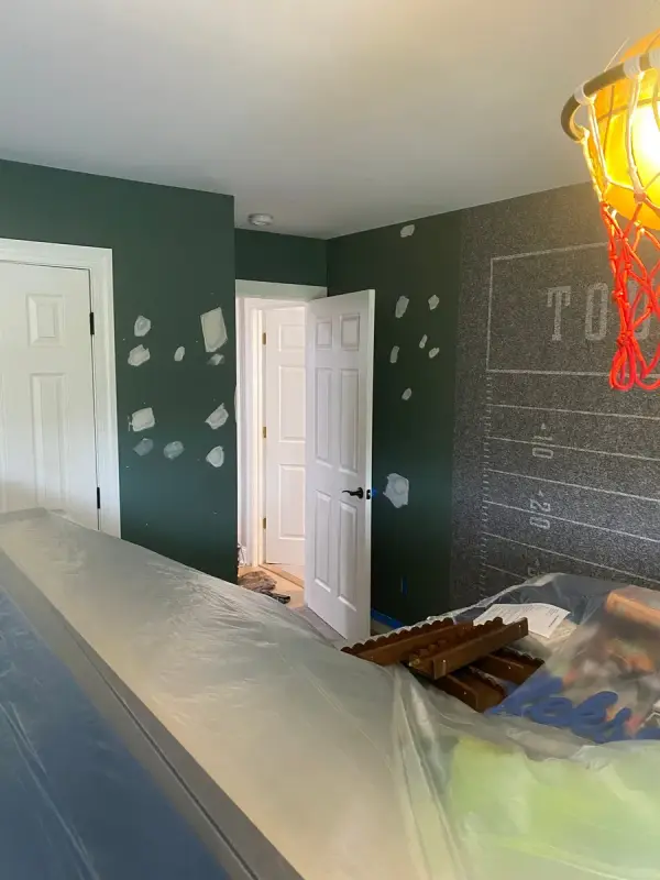 Gray football-field accent wall with lettering, room under plastic, Franklin, TN
