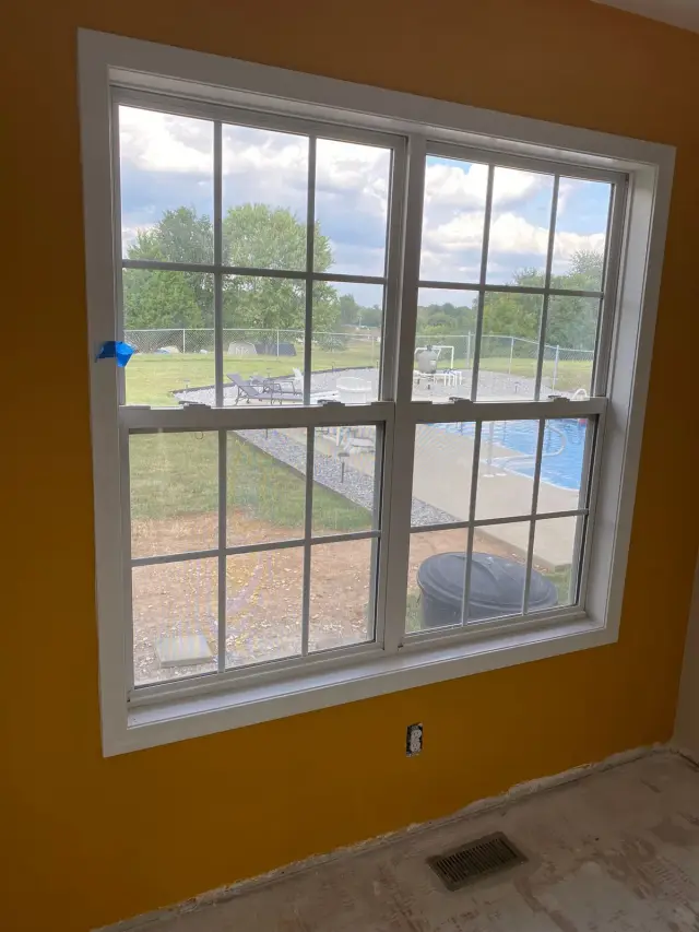 Marigold accent wall framing a white double window, Pleasant View, TN