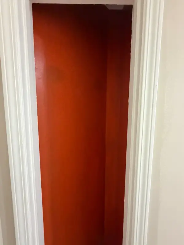 Burnt orange wall framed by white door casing, Pleasant View, TN