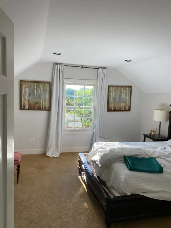 Bedroom with pale gray walls and a window between paintings, Belle Meade, TN