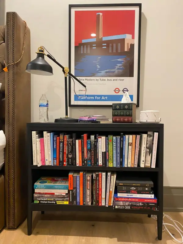 Black bookcase beside a bed, white walls, Belle Meade, TN
