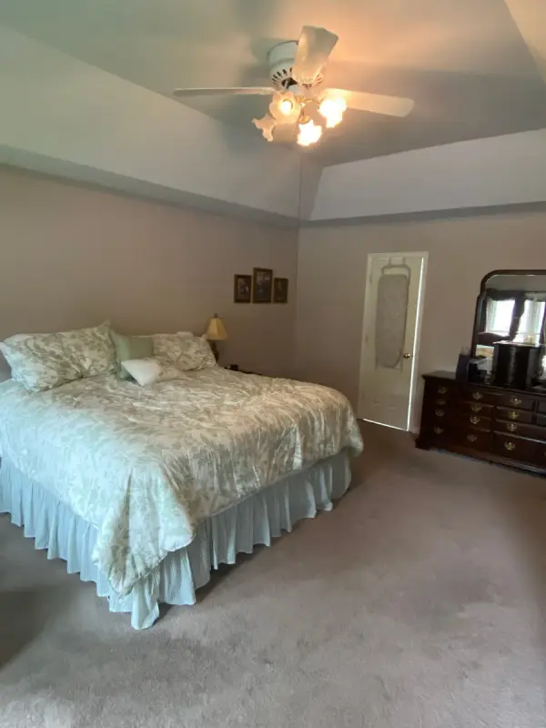 Bed and dresser under a white tray ceiling with fan, Bellevue, TN