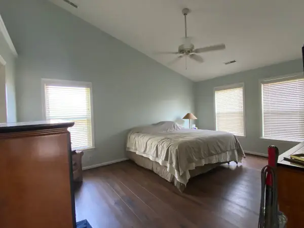 Pale blue-green bedroom under a vaulted ceiling with windows, Bellevue, TN