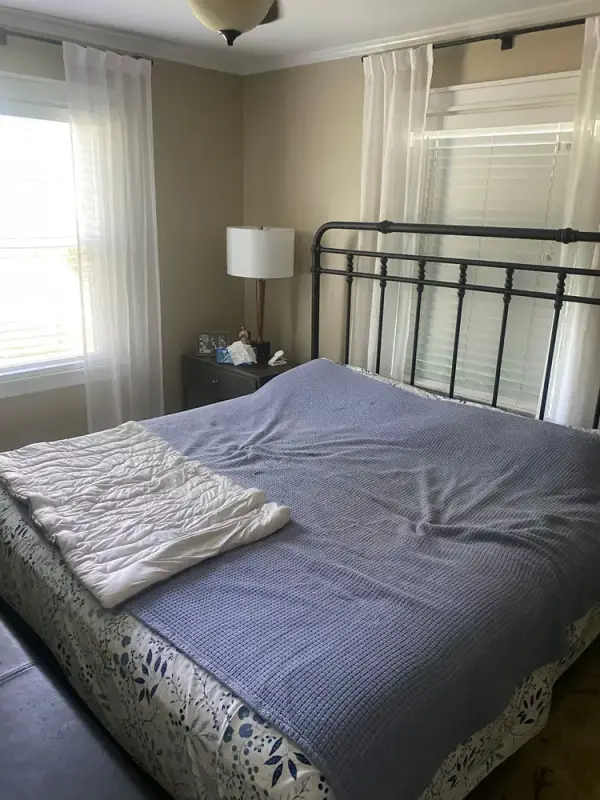 Bedroom window with white trim behind an iron bed, Fairview, TN