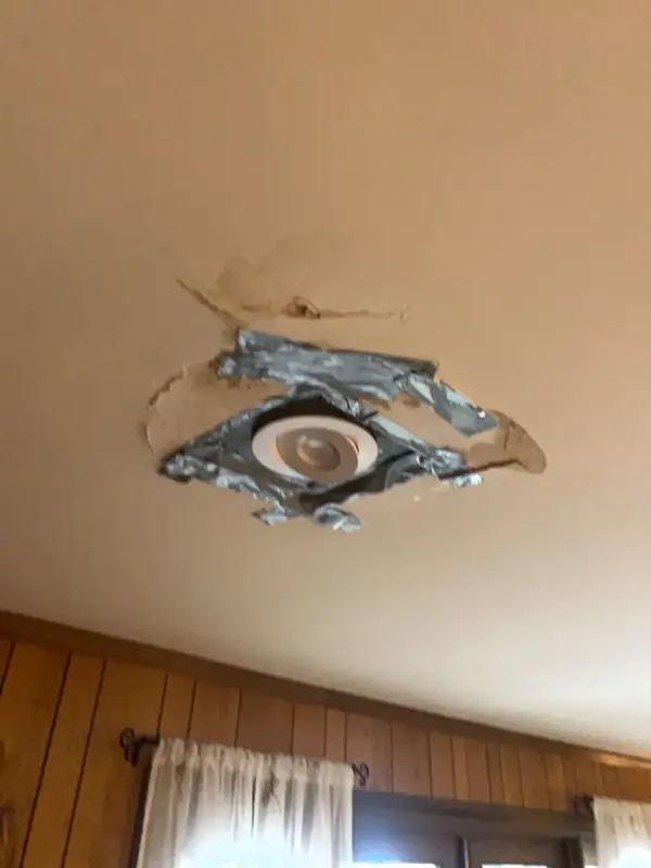 Damaged ceiling around a light fixture above wood paneling, Franklin, TN