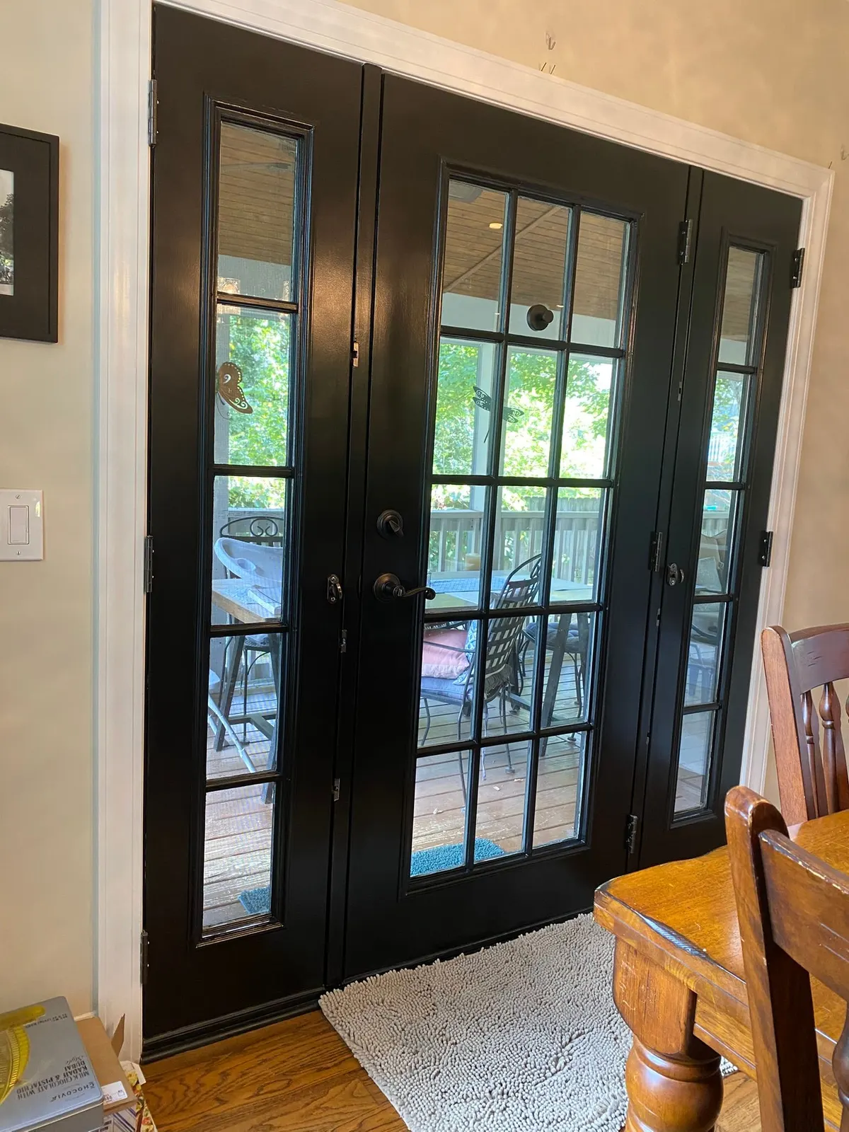 Black French doors with white casing beside a dining table, Bellevue, TN