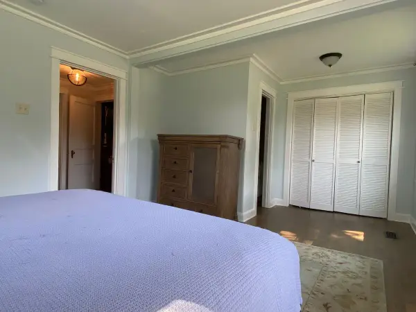 White bifold closet doors in a pale blue-gray bedroom, Fairview, TN