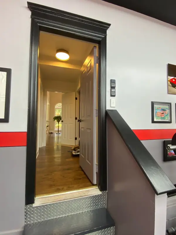 Black door casing between gray walls with a red stripe, Franklin, TN