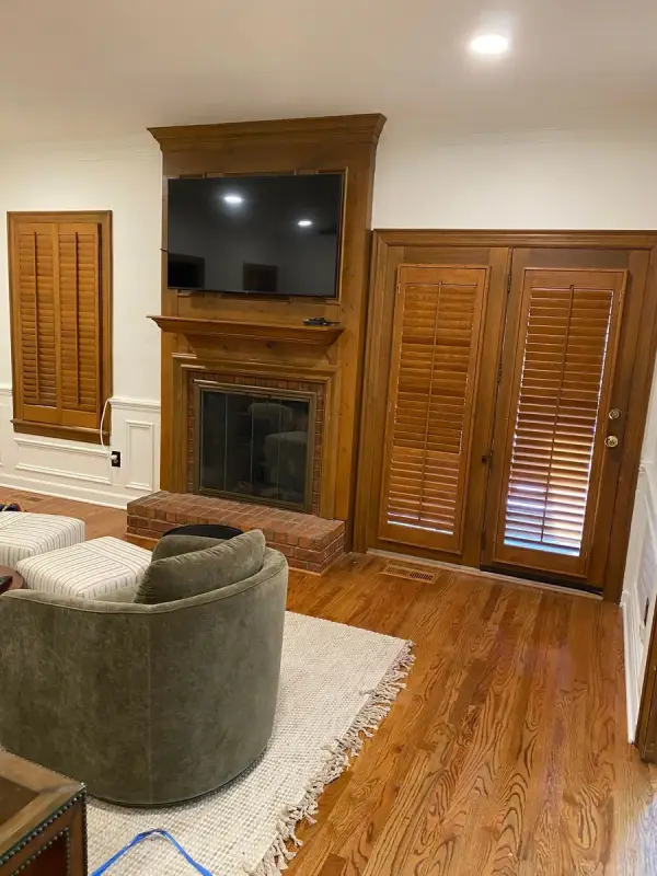 Stained wood mantel beside wood-shuttered doors before painting, Brentwood, TN