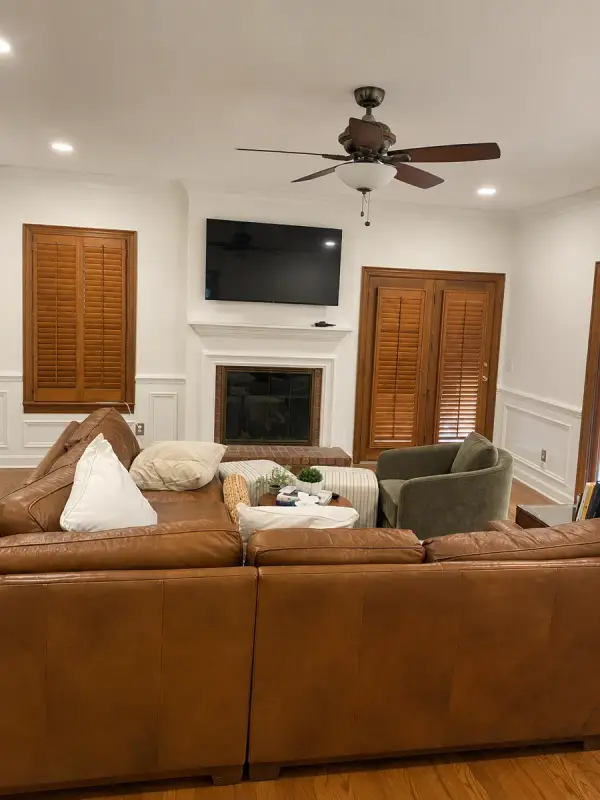White-painted fireplace surround between stained shutters and doors, Brentwood, TN