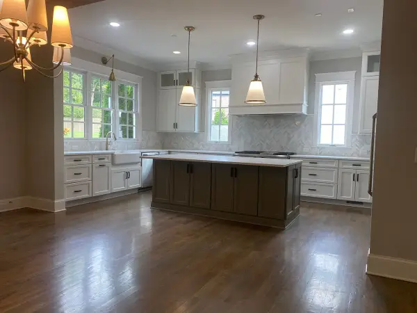 Kitchen with white perimeter cabinets and pendants over a dark island, Belle Meade, TN