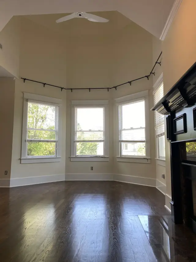 Warm white room with a five-window bay and black mantel, Brentwood, TN