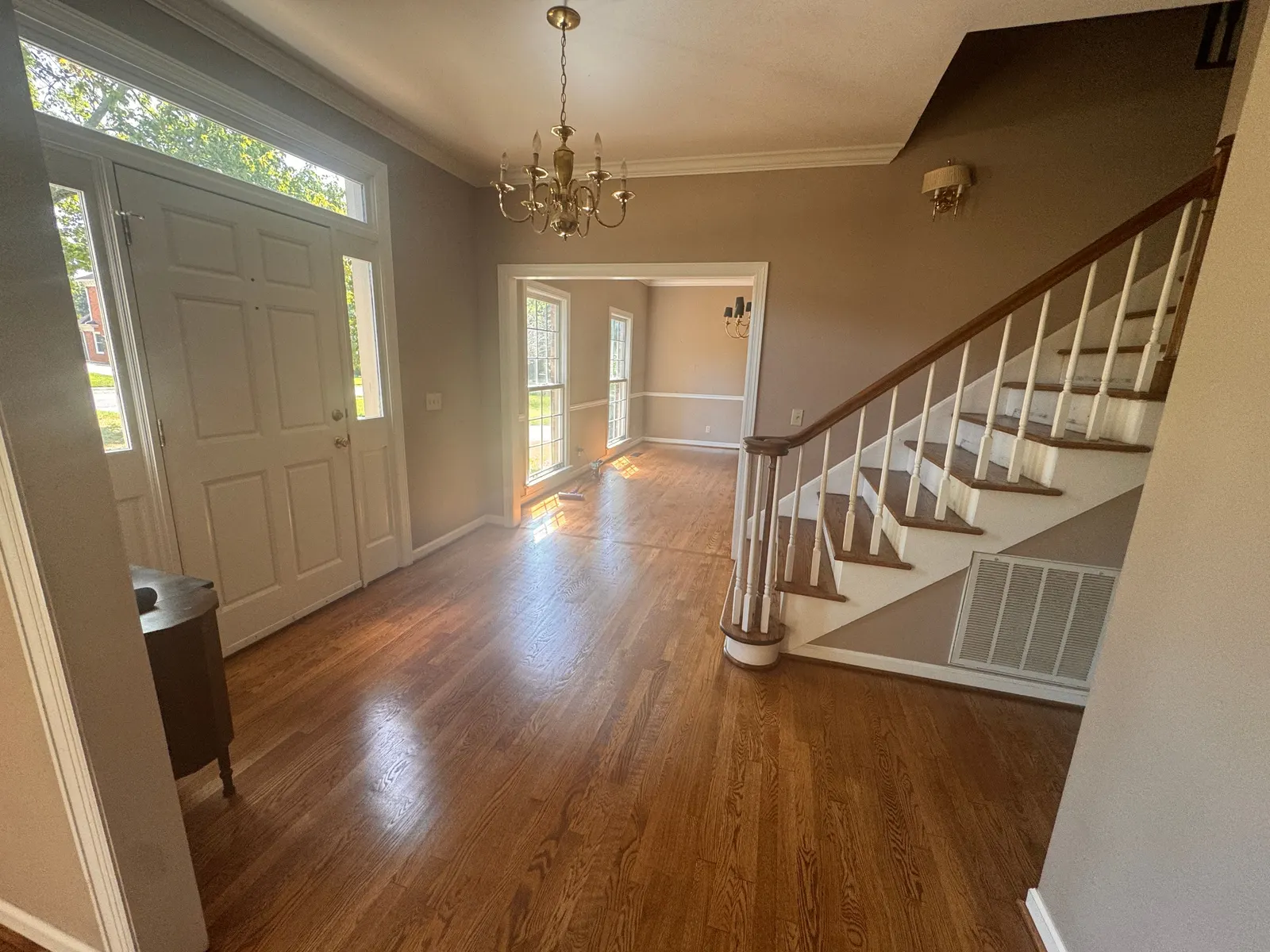 Foyer with taupe walls, white-spindled stair and front door, Bellevue, TN