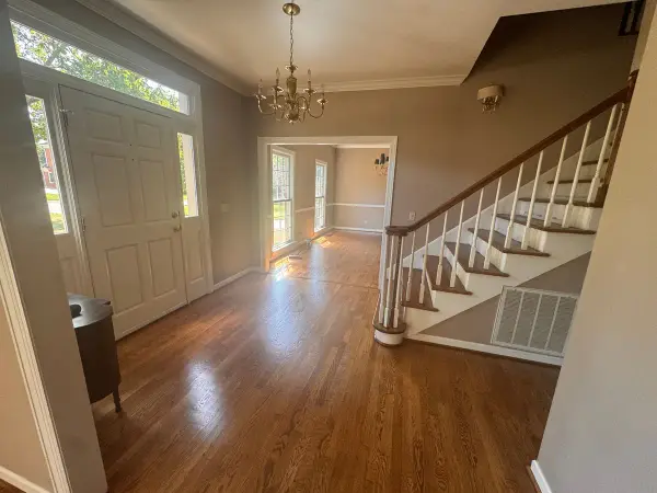 Foyer with taupe walls, white-spindled stair and front door, Bellevue, TN