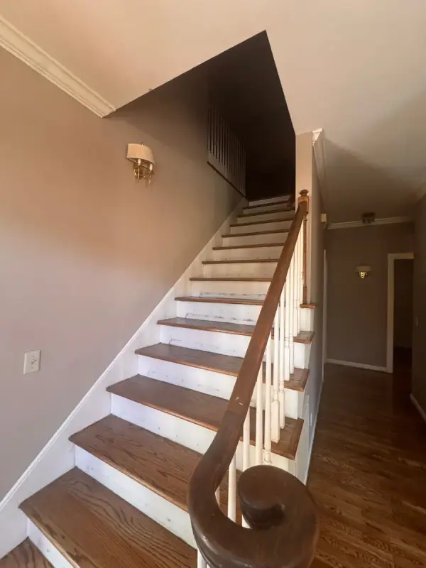 White-riser stair with stained treads and dark handrail, Bellevue, TN