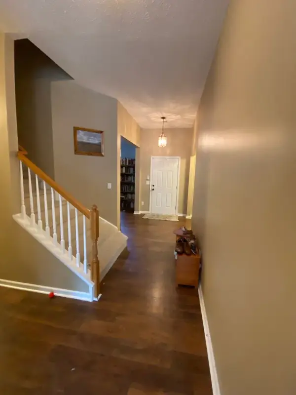 White-spindled stair with oak rail and tan walls toward the front door, Bellevue, TN
