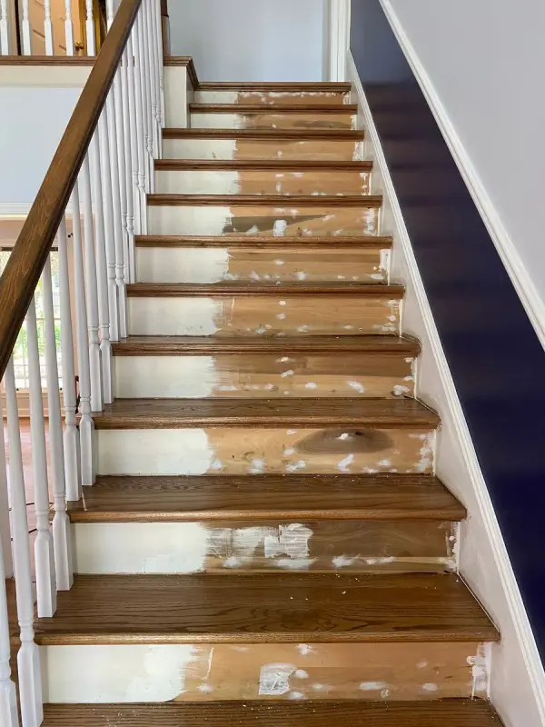 Stair risers patched mid-prep with white filler on stained treads, Bellevue, TN