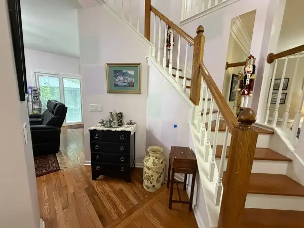 Stair with white spindles and oak rail beside a sitting area, Brentwood, TN