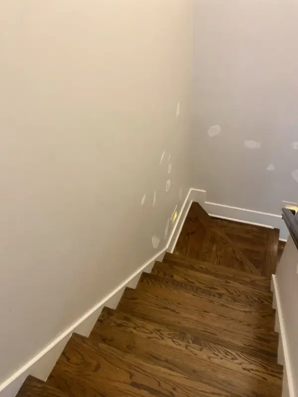 Stair walls spot-patched above white baseboards, Brentwood, TN