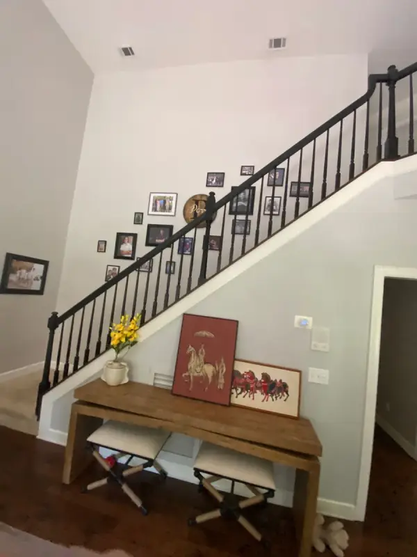 Black stair railing above a white wall and console table, Franklin, TN