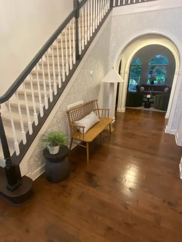 Stair with black handrail and white spindles beside an arched opening, Franklin, TN