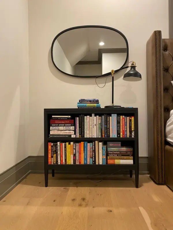 Black bookcase under an oval mirror, dark greige baseboard, Belle Meade, TN