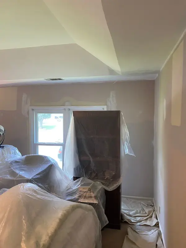 Room with patched walls and furniture under plastic, Bellevue, TN