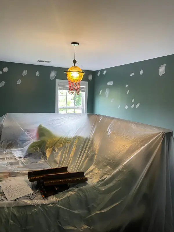 Dark green walls spot-patched, furniture under plastic, Franklin, TN