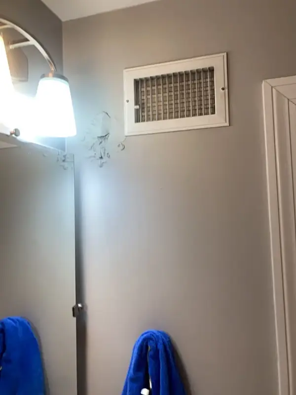 Gray wall with a white vent cover and door trim, Franklin, TN