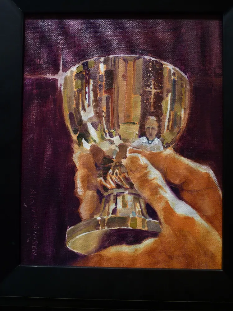 Two hands raising a gold chalice that reflects a church interior, by Alan Robinson