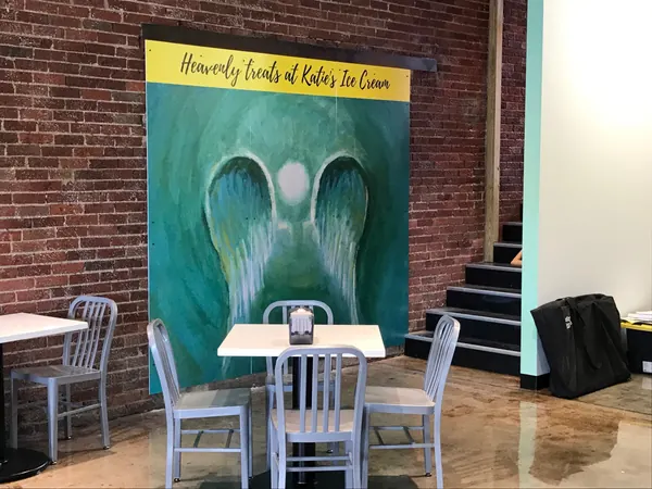 Angel wings in white on a teal wall inside Katie’s Ice Cream in Dickson, by Alan Robinson