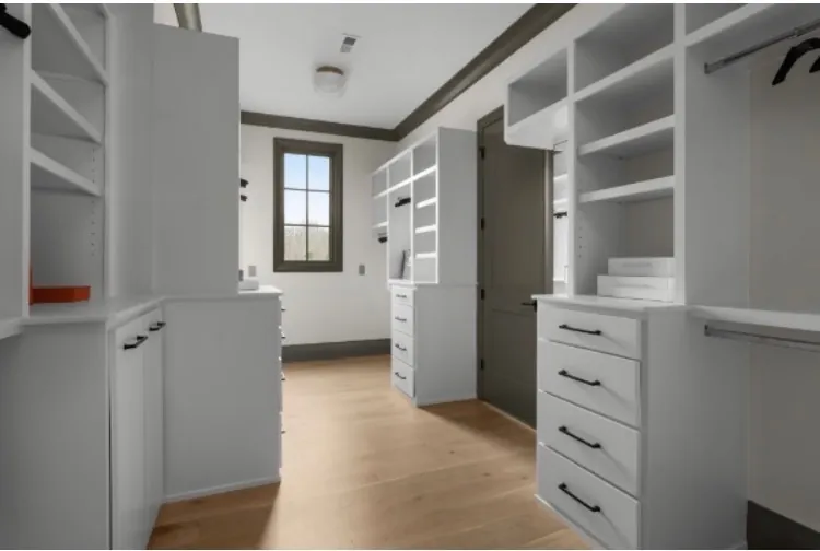 Walk-in closet with built-in drawers, cabinets and shelving painted white, the kind of detail that shapes a Belle Meade cabinet painting estimate